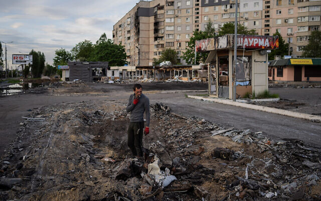 A man searches for metal scraps in a shelled neighborhood in Kharkiv, eastern Ukraine, May 19, 2022. (AP Photo/Bernat Armangue)