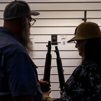 A couple examines a rifle at the George R. Brown Convention Center during the National Rifle Association (NRA) annual convention on May 27, 2022 in Houston, Texas. (Brandon Bell/Getty Images/AFP)