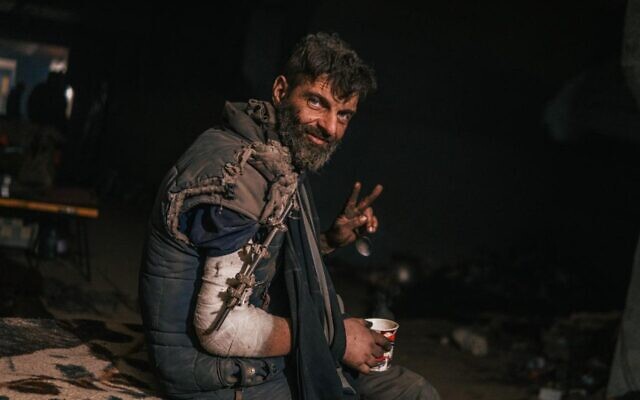 A wounded Ukrainian soldier defending the besieged Azovstal plant flashes a victory sign, May 11, 2022 (