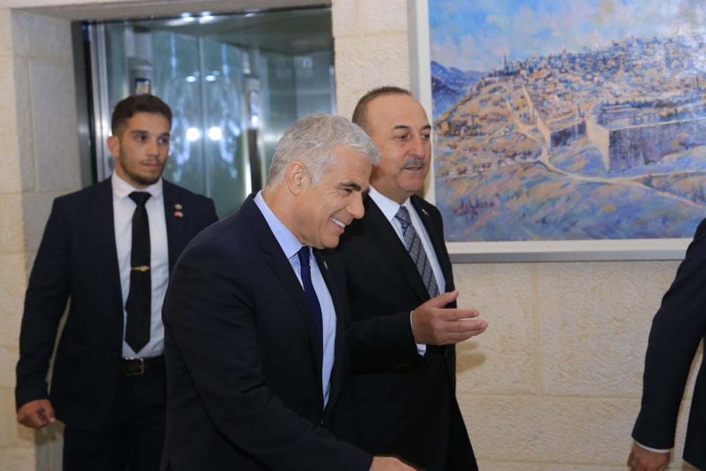 Foreign Minister Yair Lapid, center speaks with his Turkish counterpart Mevlut Cavusoglu at the Foreign Ministry in Jerusalem, May 25, 2022. (Asi Efrati/ GPO)