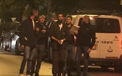 Subhi Emad Sbeihat (cuffed, center) walks through Elad with investigators to reenact the deadly terror attack, May 9, 2022 (screenshot: Channel 13)