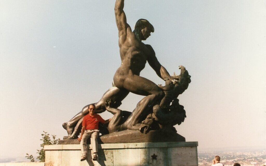 Jerry Alter sitting on the Liberty Statue at Gellert Hill in Budapest, Hungary, in this undated photo. (Courtesy Museum & Crane)