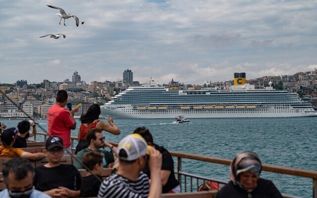Bystanders watch a Costa Venezia cruise ship in Galataport Istanbul, on June 6, 2022. (Yasin Akgul/AFP)