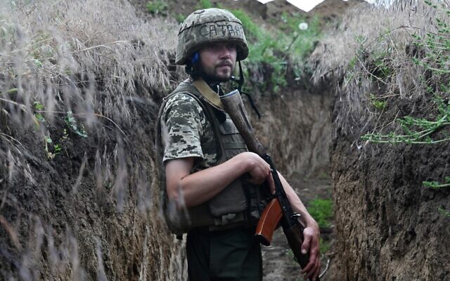 A Ukrainian serviceman walks in a trench on a position held by the Ukrainian army between southern cities of Mykolaiv and Kherson on June 12, 2022, during the Russian invasion of Ukraine. (Genya SAVILOV / AFP)