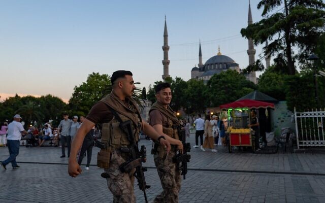 Two Turkish riot police officers walk in front of the Blue Mosque in Istanbul, on June 14, 2022. (Yasin Akgul/AFP)