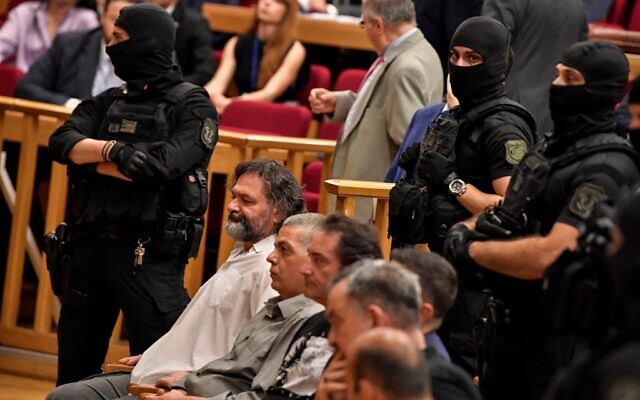 Convicted members of the golden dawn party are surrounded by special police forces  during the appeal trial in Athens on June 15, 2022. (Photo by Louisa GOULIAMAKI / AFP)