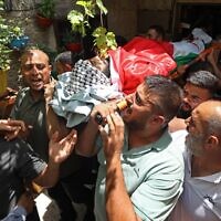 Mourners carry the body of Ali Harb, who was allegedly stabbed to death by an Israeli settler, during his funeral in the northern West Bank village of Iskaka on June 22, 2022. (JAAFAR ASHTIYEH / AFP)