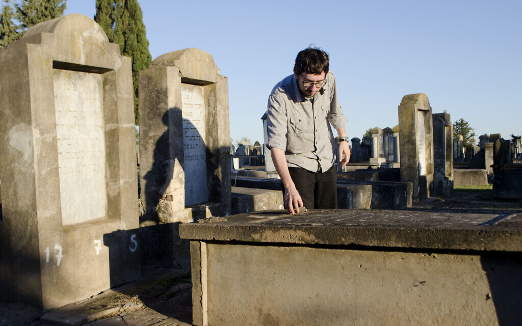 Javier Sinay visits the Jewish cemetery in Moise Ville, Argentina, during a visit to the village in 2013. (Paula Salischiker/ via JTA)