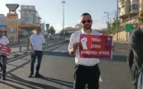 A bus driver holds a sign in Jerusalem while on strike, demanding better wages for his profession, June 6, 2022. (Screengrab, Twitter)