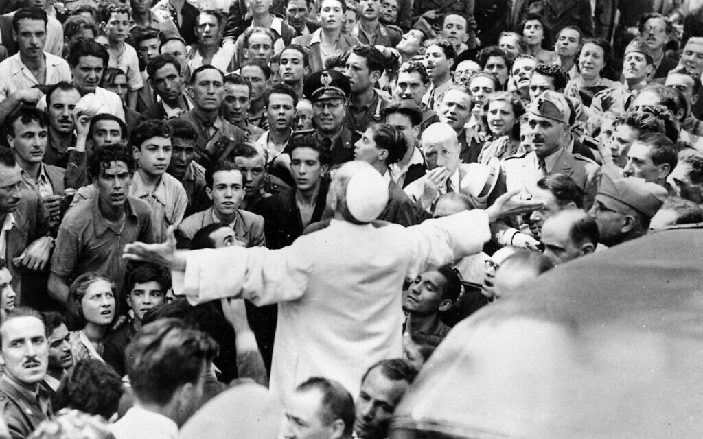 Men, women and soldiers gather around Pope Pius XII, his arms outstretched, on October 15, 1943, during his inspection tour of Rome, Italy, after an American air raid that August. (AP Photo, file)