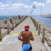 A jogger runs along a marina in Herzliya, Israel, June 2, 2021. (AP Photo/David Goldman)