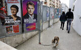 Illustrative: A dog walks past presidential campaign posters during the first round of the French presidential election, in Strasbourg, eastern France, April 10, 2022. (AP Photo/Jean-Francois Badias)