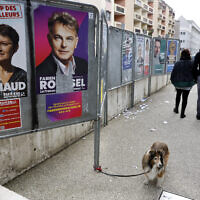 Illustrative: A dog walks past presidential campaign posters during the first round of the French presidential election, in Strasbourg, eastern France, April 10, 2022. (AP Photo/Jean-Francois Badias)