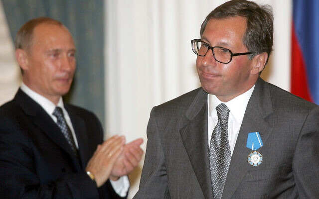 Russian President Vladimir Putin, left, applauds then-Alfa-Bank head Pyotr Aven after awarding him with the Order of Merit to the Fatherland during a ceremony in the Kremlin, Moscow, July 25, 2005. (AP Photo/ Alexander Nenenov, Pool)