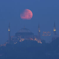A full moon rises above the iconic Haghia Sophia in Istanbul, Turkey, early May 16, 2022. (Mucahid Yapici/AP)