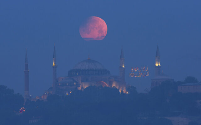 A full moon rises above the iconic Haghia Sophia in Istanbul, Turkey, early May 16, 2022. (Mucahid Yapici/AP)