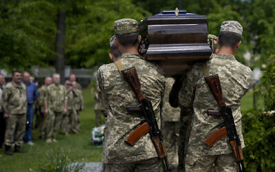 Ukrainian servicemen carry the coffin with the remains of Army Col. Oleksander Makhachek during his funeral in Zhytomyr, Ukraine, Friday, June 3, 2022. According to combat comrades Makhachek was killed fighting Russian forces when a shell landed in his position on May 30. (AP Photo/Natacha Pisarenko)