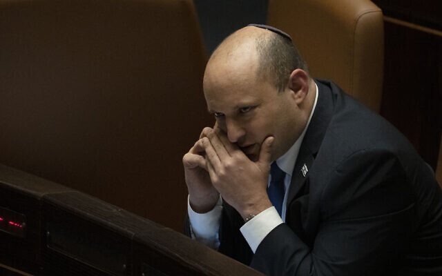 Prime Minister Naftali Bennett makes a call before voting on a law on the legal status of Israelis in the West Bank, during a session of the Knesset, Monday, June 6, 2022. (AP Photo/ Maya Alleruzzo)