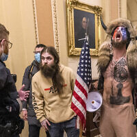 Supporters of President Donald Trump, including Jacob Chansley, right with fur hat, are confronted by US Capitol Police officers outside the Senate Chamber inside the Capitol in Washington, Jan. 6, 2021. (Manuel Balce Ceneta/AP)