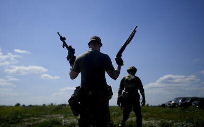 A civilian militia man holds a shotgun and a rifle during training at a shooting range in outskirts Kyiv, Ukraine, June 7, 2022. (Natacha Pisarenko/AP)