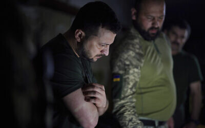In this photo provided by the Ukrainian Presidential Press Office, Ukrainian President Volodymyr Zelensky, left, listens to a servicemen report close to the front line in Donetsk region, Ukraine, June 5, 2022. (Ukrainian Presidential Press Office via AP)