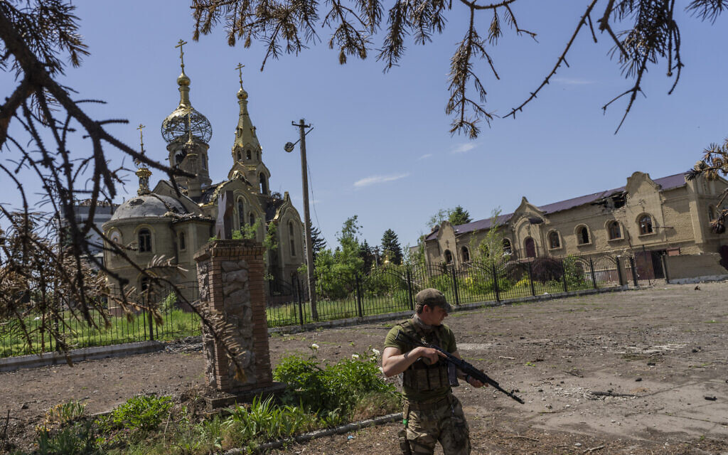A Ukrainian serviceman patrols a village near the frontline in the Donetsk oblast region, eastern Ukraine, June 2, 2022. (Bernat Armangue/AP)