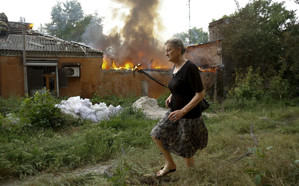 A woman runs from a house that's on fire after shelling in Donetsk, on the territory which is under the Government of the Donetsk People's Republic control, eastern Ukraine, Friday, June 3, 2022.  (AP Photo/Alexei Alexandrov, file)