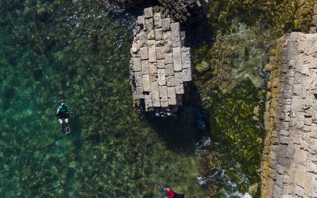 Snorkel-diving volunteers collect trash during World Ocean Day event in the Mediterranean ancient Caesarea's Roman-period port, Israel, June 10, 2022. (AP Photo/Ariel Schalit)