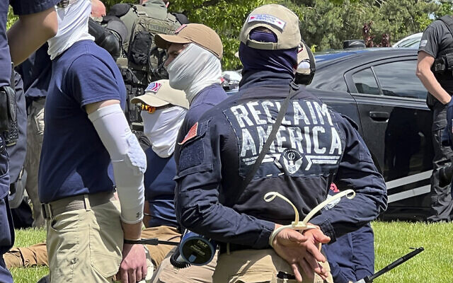 Authorities arrest members of the white supremacist group Patriot Front near an Idaho pride event, June 11, 2022, after they were found packed into the back of a U-Haul truck with riot gear. (Georji Brown via AP)