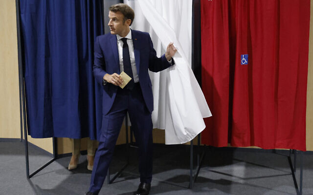 France's President Emmanuel Macron leaves the voting booth after voting in the first round of French parliamentary election at a polling station in Le Touquet, northern France, June 12, 2022. (Ludovic Marin, Pool via AP)