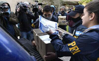 Police officers confiscate a box of documents during a judicial raid at the Plaza Central Hotel where the crew of a Venezuelan-owned Boeing 747 cargo plane are staying, in Buenos Aires, Argentina, Tuesday, June 14, 2022. (AP Photo/Gustavo Garello)