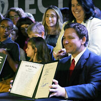 Florida Gov. Ron DeSantis holds up a 15-week abortion ban law after signing it in Kissimmee, Florida, April 14, 2022. (AP/John Raoux, File)