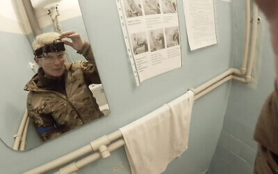 Yuliia Paievska, known as Taira, looks in a mirror and turns off her camera in Mariupol, Ukraine, on February 27, 2022. (Yuliia Paievska via AP)