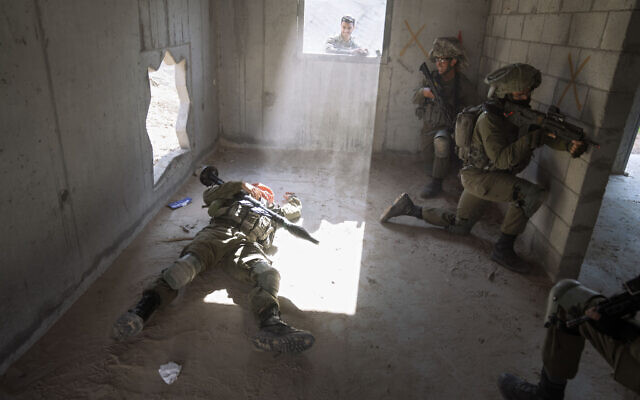 An Israeli soldier pretending to be dead Palestinian fighter lies on the ground during a training session simulating urban warfare at the Zeelim army base, southern Israel, Jan. 4, 2022. (Oded Balilty/AP)