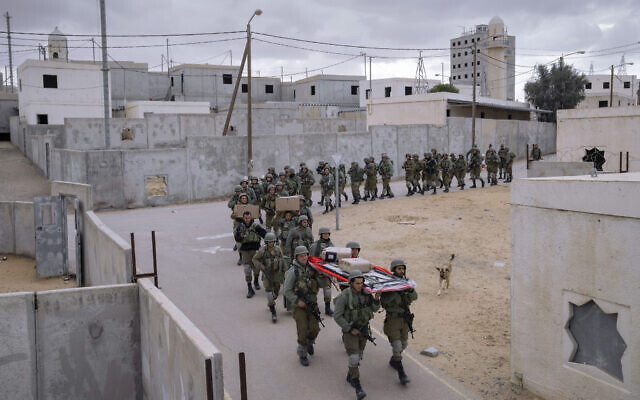 Israeli soldiers carry supplies at the end of an urban warfare exercise session at an army training facility at the Tzeelim army base, southern Israel, Feb. 10, 2022. (Oded Balilty/AP)
