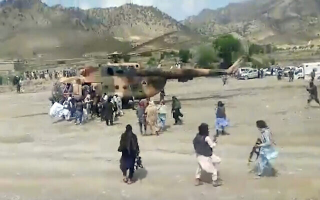 In this image taken from video from Bakhtar State News Agency, Taliban fighters secure a government helicopter to evacuate injured people in Gayan district, Paktika province, Afghanistan, June 22, 2022 (Bakhtar State News Agency via AP)