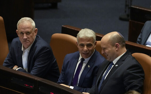 Defense Minister Benny Gantz, left, Foreign Minister Yair Lapid, center, and Prime Minister Naftali Bennett attend a preliminary vote on a bill to dissolve parliament, at the Knesset in Jerusalem, June 22, 2022  (AP Photo/Maya Alleruzzo)
