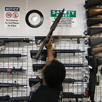 Illustrative: Sales associate Elsworth Andrews grabs an AR-15-style rifle to show it to a customer at Burbank Ammo & Guns in Burbank, California, June 23, 2022. (AP Photo/Jae C. Hong)