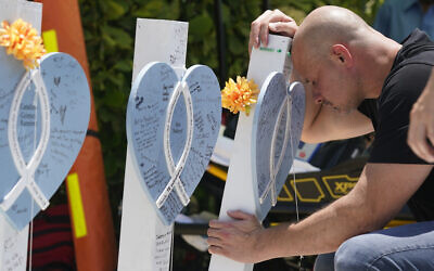 Lazaro Carnero mourns for his best friend Edgar Gonzalez, during a remembrance event at the site of the Champlain Towers South building collapse, Friday, June 24, 2022, in Surfside, Fla. Friday marks the anniversary of the oceanfront condo building collapse that killed 98 people in Surfside, Florida. (AP Photo/Wilfredo Lee)