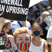 A person holds up a sign referencing the Stonewall Inn, during a queer liberation march for Black Lives Matter and against police brutality, June 28, 2020, in New York. (AP Photo/Kathy Willens, File)