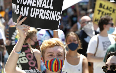 A person holds up a sign referencing the Stonewall Inn, during a queer liberation march for Black Lives Matter and against police brutality, June 28, 2020, in New York. (AP Photo/Kathy Willens, File)