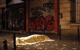 A victim under a blanket lays dead outside the Bataclan theater in Paris, Nov. 13, 2015. (AP Photo/Jerome Delay)