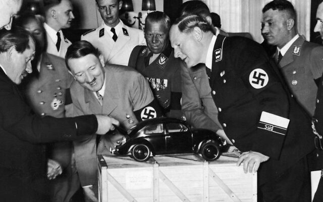 Adolf Hitler admires a model of the Volkswagen car. He is with the designer Ferdinand Porsche, left, and various Nazi officials. (public domain)