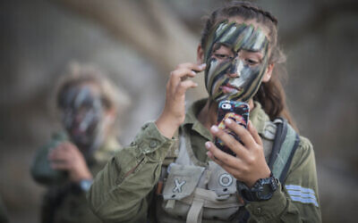 Soldiers of the Caracal Battalion put camouflage makeup on in preparation for a 16-kilometer overnight journey to complete their training course, in Azoz village, southern Israel, near the border with Egypt, September 3, 2014. (Hadas Parush/Flash90)