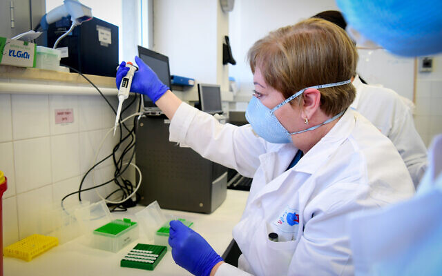 Illustrative: Medical staff at Barzilai Medical Center in Ashkelon handle a lab sample in March 2020 (Flash90)