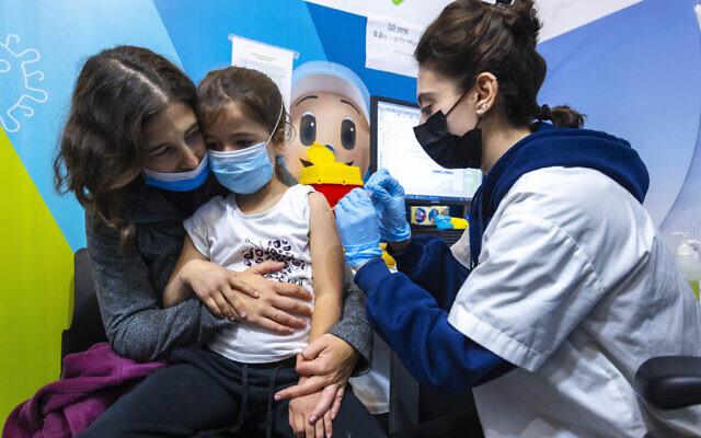 Children receive their dose of COVID-19 vaccine, at a vaccination center in Jerusalem on December 30, 2021. (Olivier Fitoussi/Flash90)