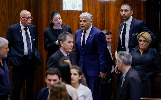 Foreign Minister Yair Lapid (Yesh Atid) with Merav Michaeli, Minister of Transport (Labor), speak ahead of a preliminary vote to dissolve the Knesset for new elections, on June 22, 2022. (Olivier Fitoussi/Flash90)