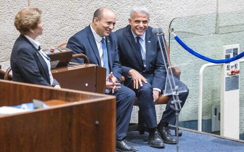 Prime Minister Naftali Bennett and Foreign Minister Yair Lapid speak during a Knesset discussion, June 27, 2022. (Olivier Fitoussi/Flash90)