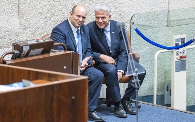 Prime Minister Naftali Bennett and Foreign Minister Yair Lapid speak during a Knesset discussion, June 27, 2022. (Olivier Fitoussi/Flash90)