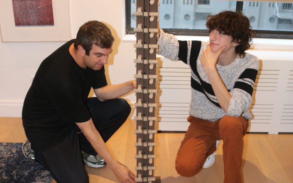 A.J. Jacobs and his son with the generation puzzle called 'Jacobs' Ladder' custom designed by Oskar van Deventer. The puzzle will take 1.2 decillion moves to solve. (Julie Jacobs)